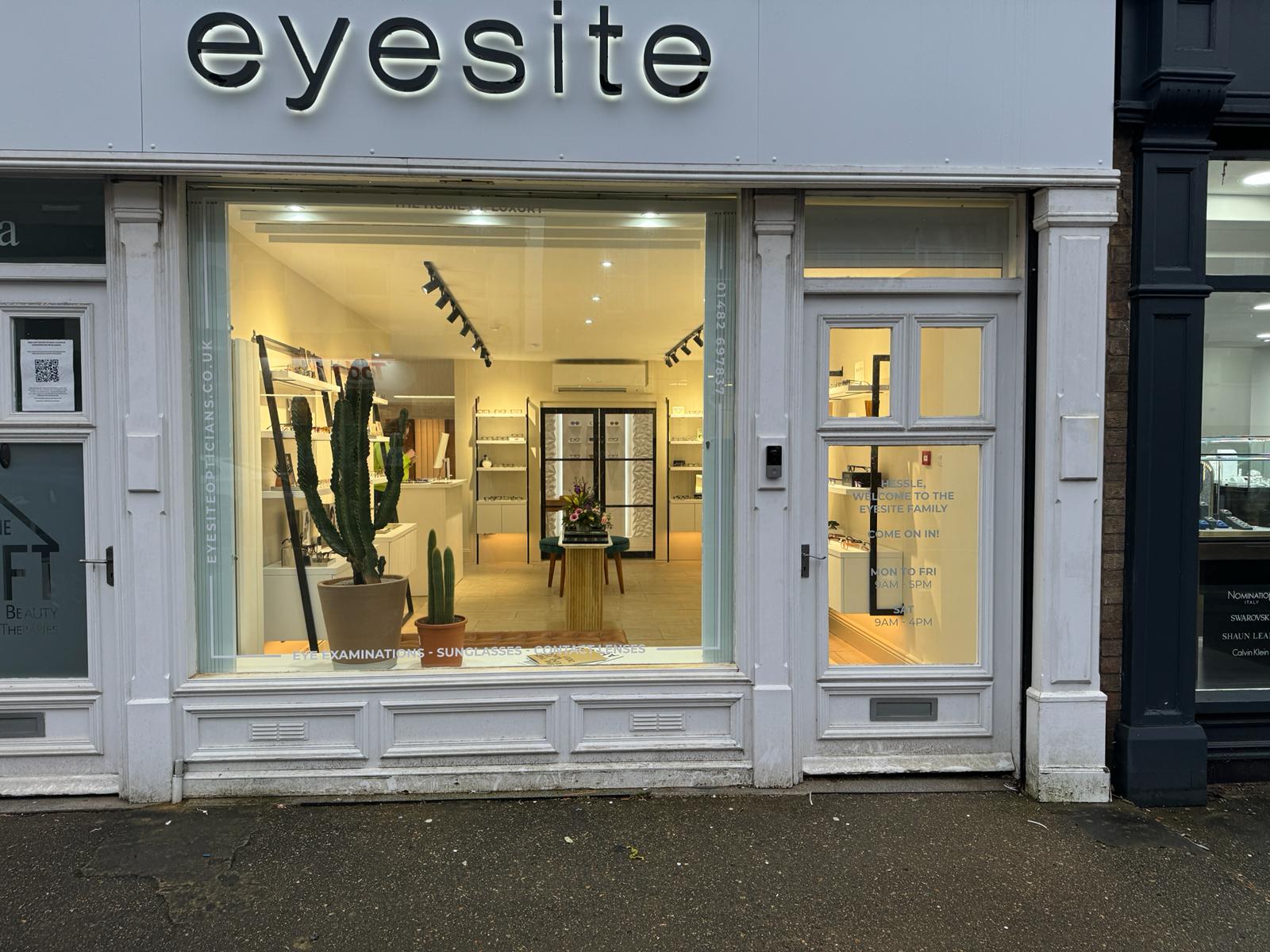Eyesite opticians shop front with large display window showing eyewear displays, cacti, and a welcoming interior