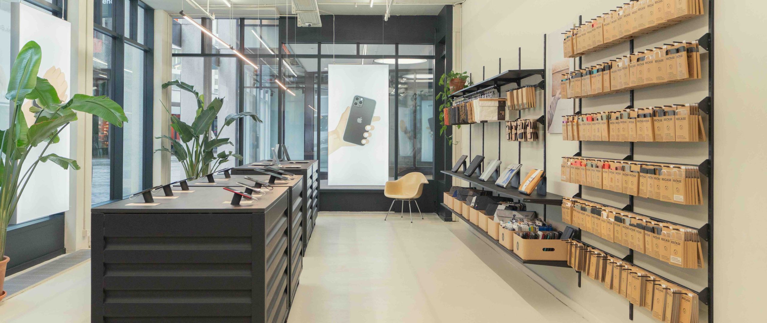 Modern retail store interior with phone accessories displayed on wall shelving and central display units.