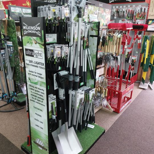 Wilkinson Sword Ultralight garden tools aisle display in a garden centre, featuring pruners, loppers, and spades