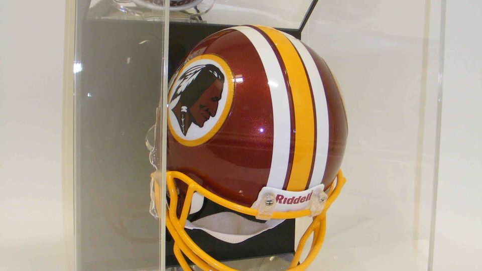 Riddell mini American football helmet displayed inside a clear acrylic case on a black base