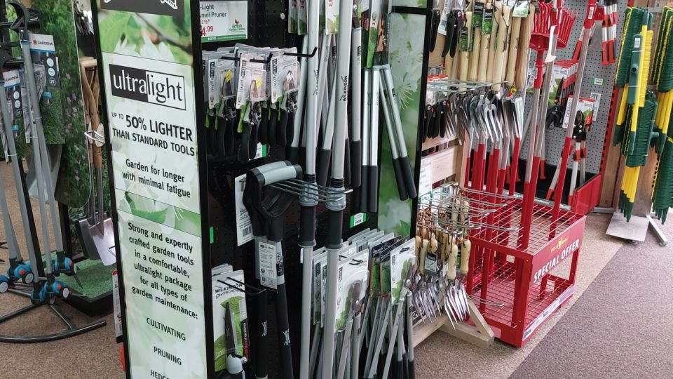 Wilkinson Sword Ultralight garden tools aisle display in a garden centre, featuring pruners, loppers, and spades