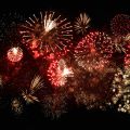 Vivid red and gold fireworks bursting across a dark night sky in a spectacular display